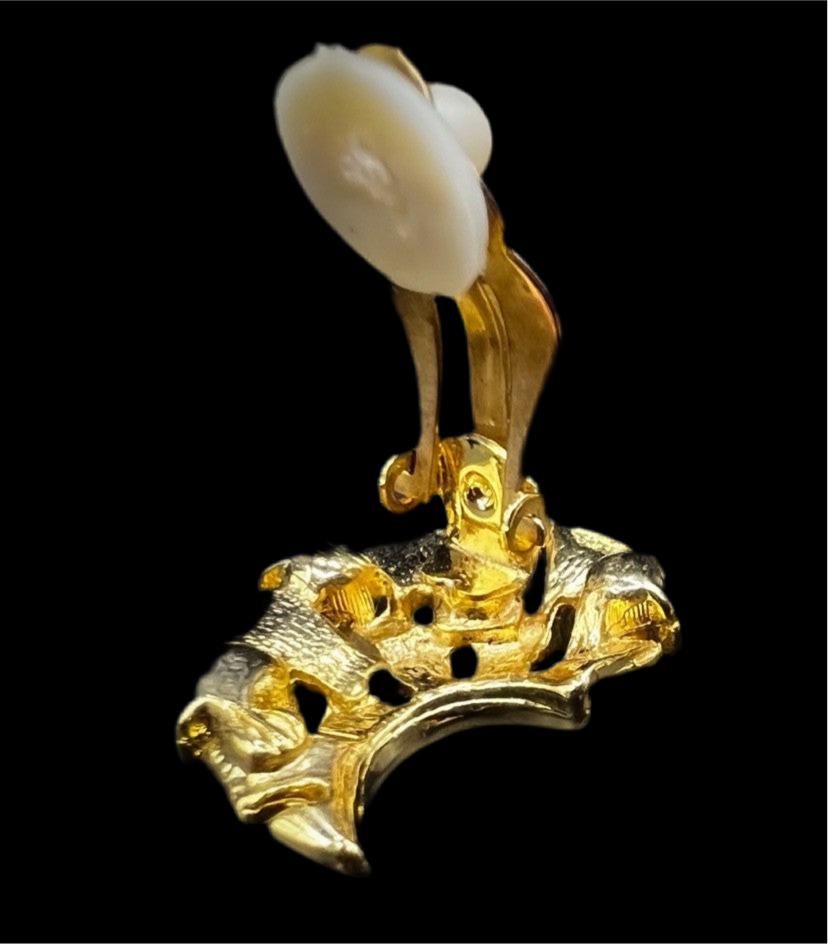 Side view of the vintage clip-on earring showing the gold-plated clasp mechanism and single faux pearl at the top.