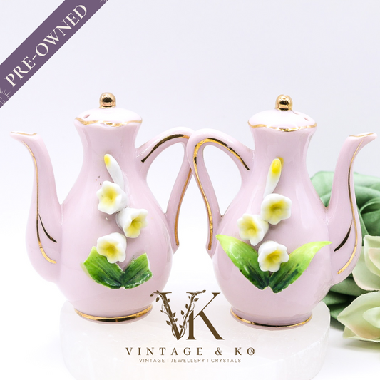 Pair of pink ceramic teapots with floral designs 