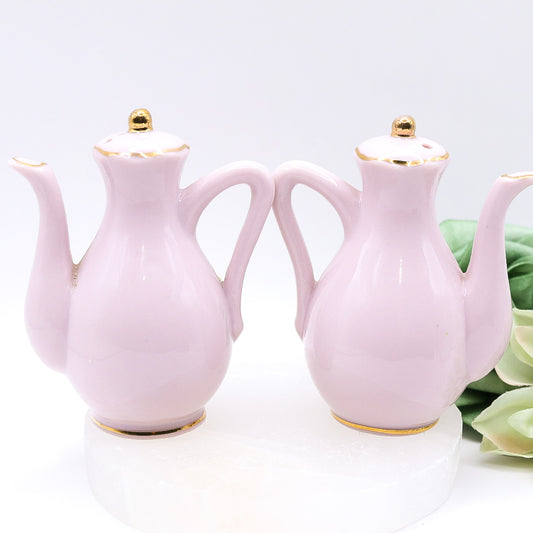 Pair of pink ceramic teapots with floral designs 
