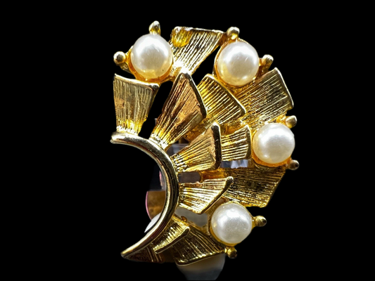 Gold-tone fan-shaped clip-on earring adorned with five faux pearls and textured panels, styled against a black background.